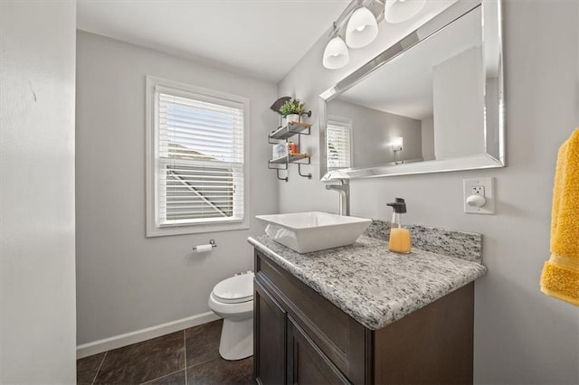 bathroom with toilet, tile patterned flooring, baseboards, and vanity