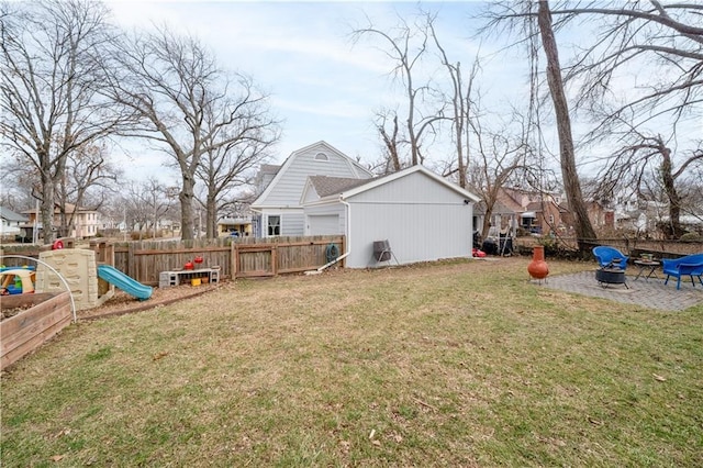 view of yard featuring a patio area, a fenced backyard, a playground, and a fire pit