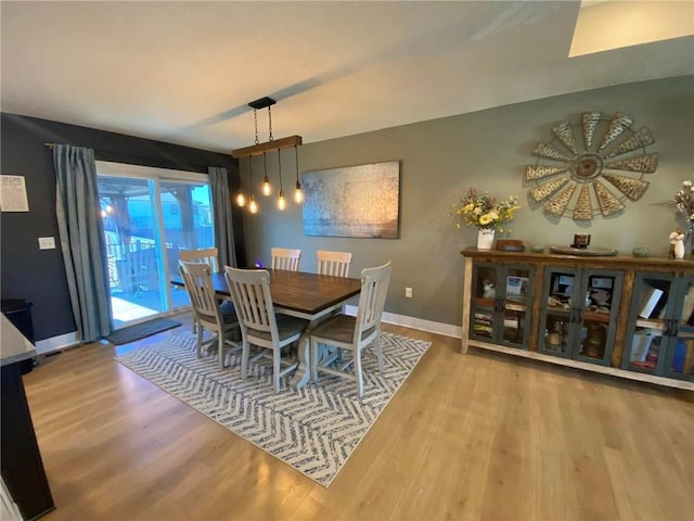 dining room featuring light wood-type flooring and baseboards