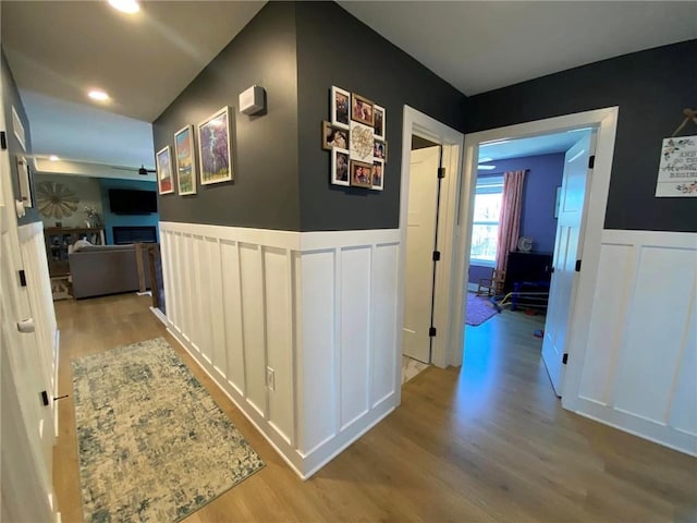 hall with a wainscoted wall and light wood-type flooring