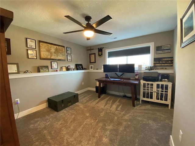 home office featuring ceiling fan, a textured ceiling, dark carpet, and baseboards