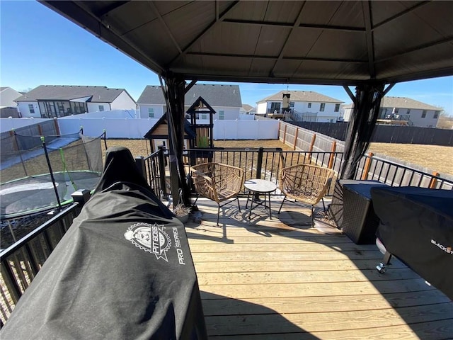 wooden deck with a gazebo, a fenced backyard, and a residential view