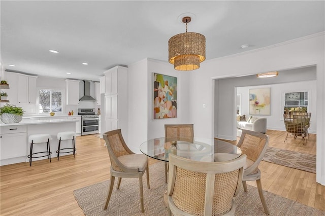 dining area featuring a notable chandelier, ornamental molding, light wood-style flooring, and recessed lighting