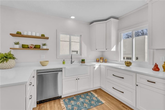 kitchen featuring a sink, white cabinets, dishwasher, and light countertops