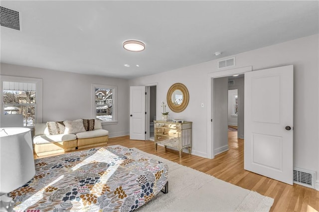 bedroom featuring light wood-type flooring, visible vents, and baseboards