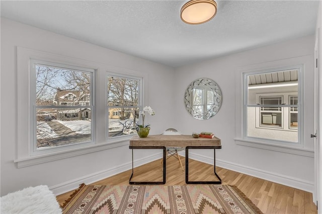 office area with a healthy amount of sunlight, baseboards, and wood finished floors