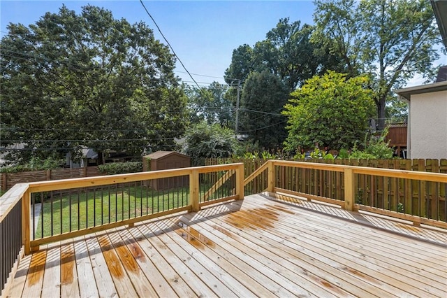 wooden terrace with a yard, a storage unit, an outdoor structure, and a fenced backyard