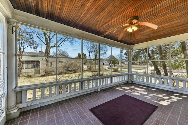 unfurnished sunroom with a ceiling fan and wooden ceiling