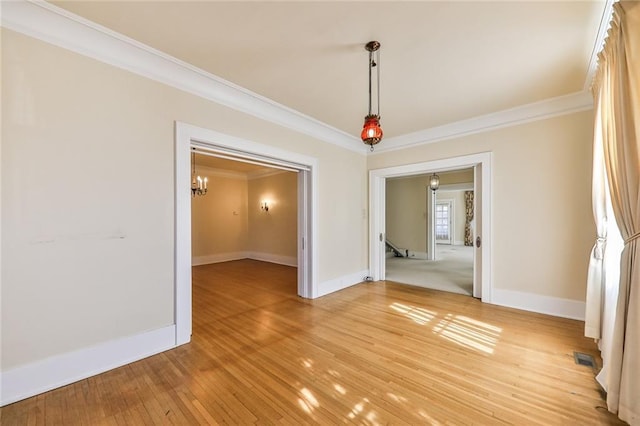 unfurnished dining area featuring ornamental molding, visible vents, light wood-style floors, and baseboards