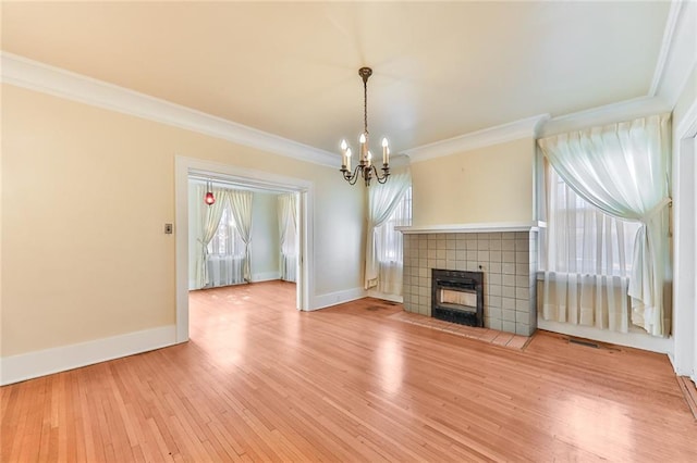 unfurnished living room with baseboards, plenty of natural light, ornamental molding, and wood finished floors