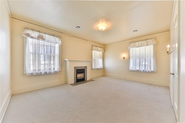 unfurnished living room featuring carpet floors, visible vents, and a fireplace