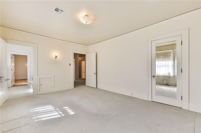 carpeted spare room featuring visible vents