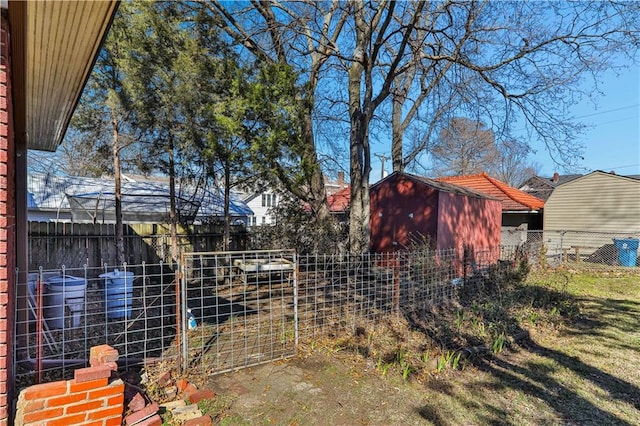 view of yard with an outbuilding, a storage unit, and a fenced backyard