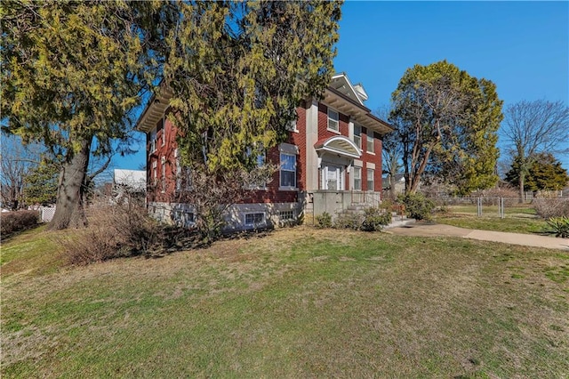 view of front of home with fence, a front lawn, and brick siding