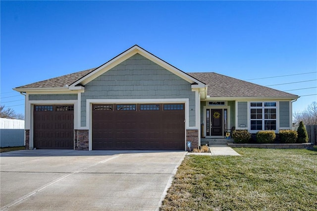 view of front of property with a garage, a front yard, concrete driveway, and stone siding