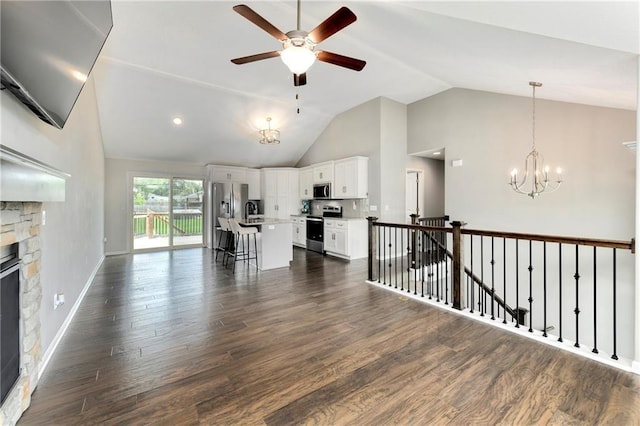 living area with dark wood-style floors, a fireplace, high vaulted ceiling, baseboards, and ceiling fan with notable chandelier