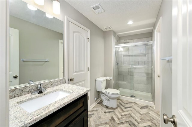 bathroom featuring visible vents, toilet, a textured ceiling, vanity, and a shower stall