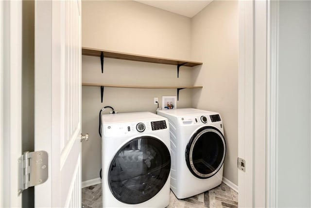 washroom with laundry area, separate washer and dryer, brick floor, and baseboards