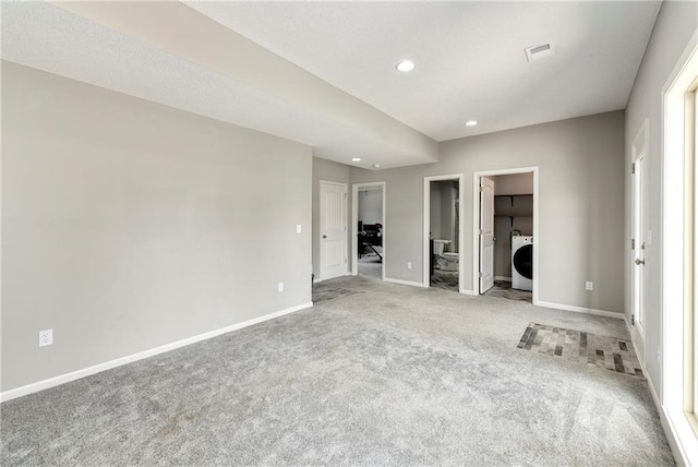 spare room featuring washer / dryer, visible vents, baseboards, light colored carpet, and recessed lighting