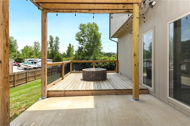 deck with a patio area, fence, a fire pit, and a lawn