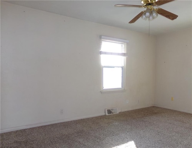 spare room with carpet, visible vents, and a ceiling fan