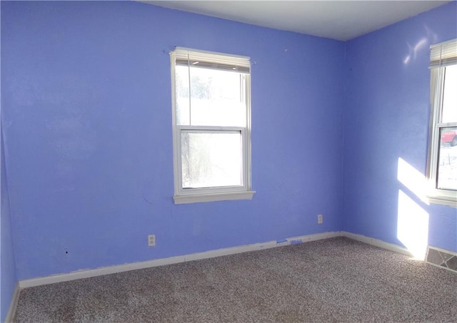 carpeted empty room with visible vents and baseboards