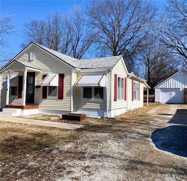 view of front of property with driveway and roof with shingles