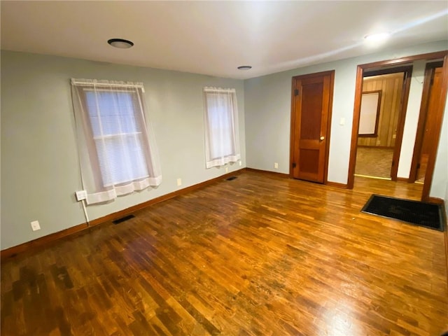 interior space featuring baseboards, visible vents, and wood finished floors