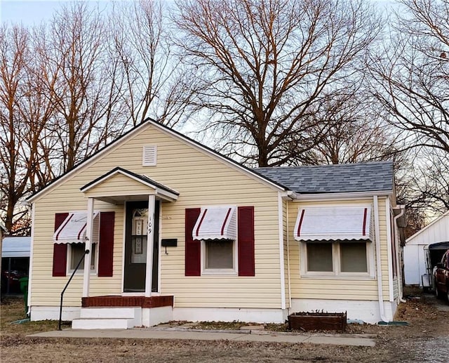 bungalow featuring roof with shingles