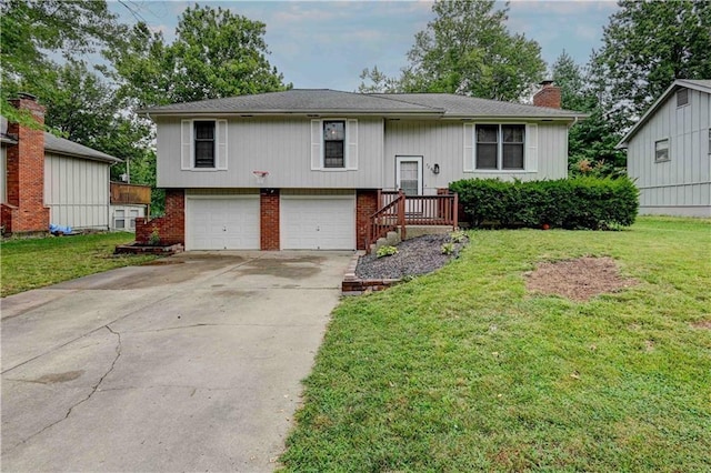 raised ranch with brick siding, concrete driveway, a chimney, an attached garage, and a front yard