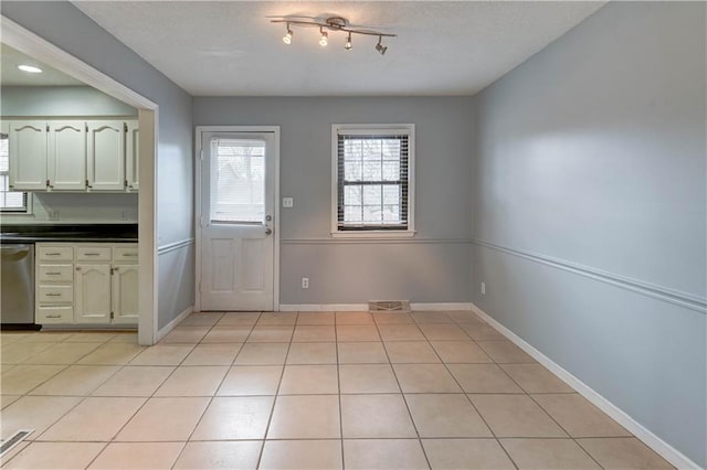 interior space with light tile patterned floors, visible vents, and baseboards