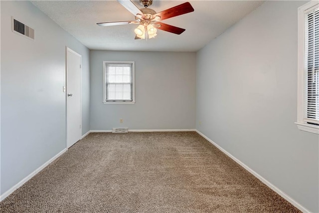 unfurnished room with a ceiling fan, carpet, visible vents, and baseboards