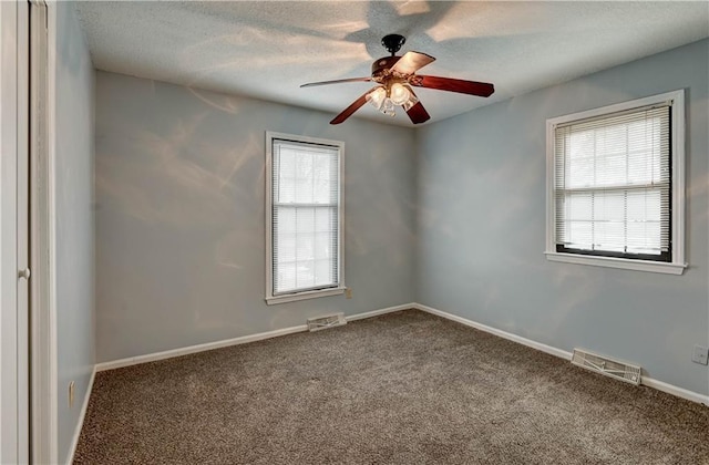 spare room featuring a healthy amount of sunlight, baseboards, visible vents, and carpet flooring