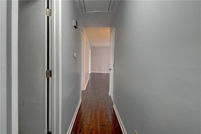 hall with attic access, baseboards, and wood finished floors