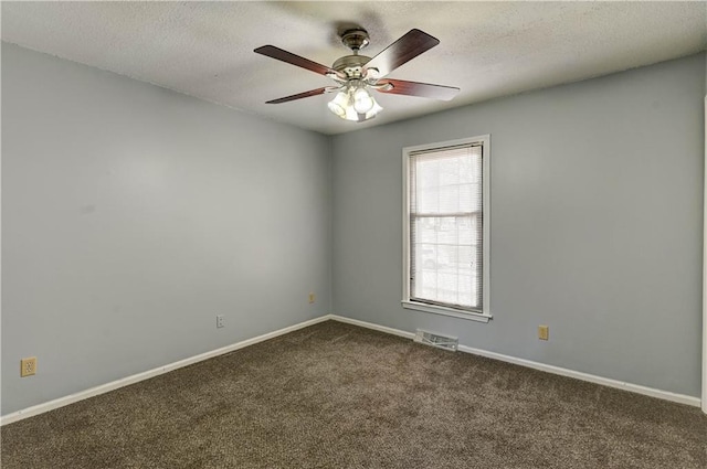 unfurnished room featuring dark colored carpet, visible vents, a textured ceiling, and baseboards