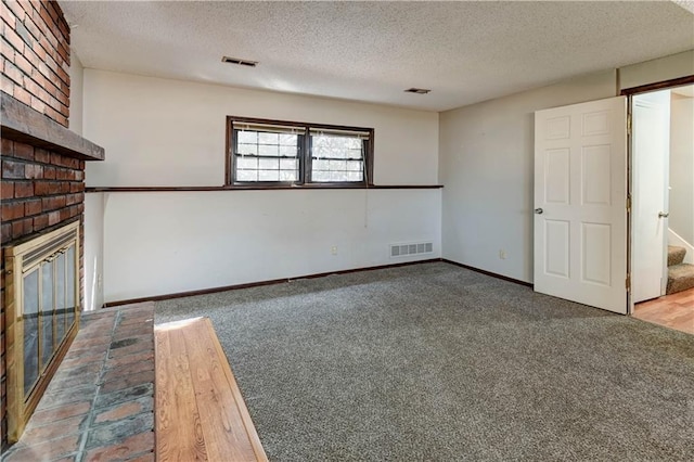 unfurnished living room with carpet, visible vents, a brick fireplace, a textured ceiling, and stairs