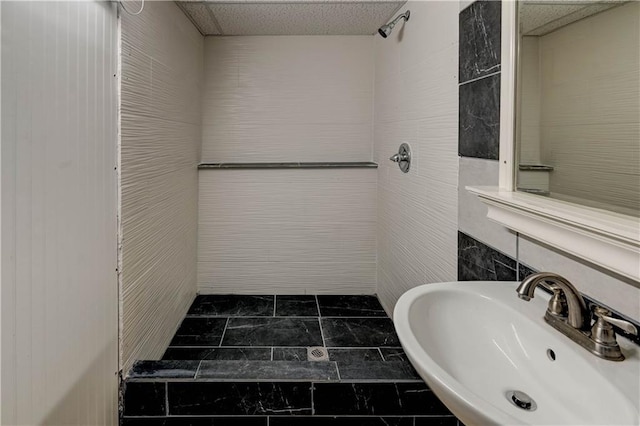 full bath featuring a sink and a tile shower