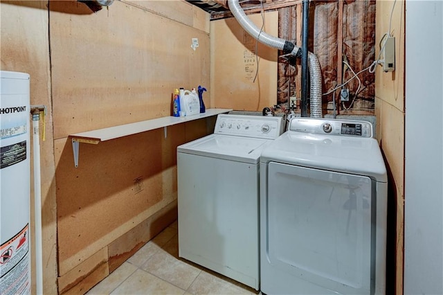 clothes washing area with laundry area, water heater, independent washer and dryer, and light tile patterned floors