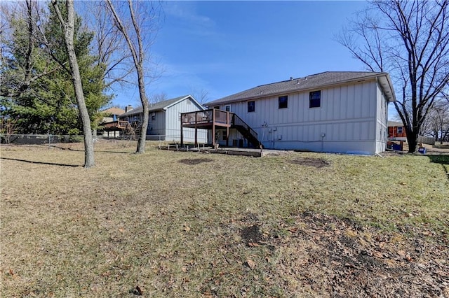 rear view of property with a yard, fence, a deck, and board and batten siding