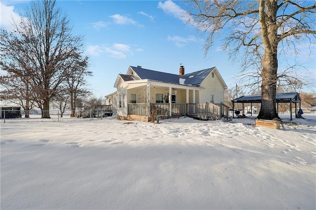 exterior space with covered porch, metal roof, and a chimney