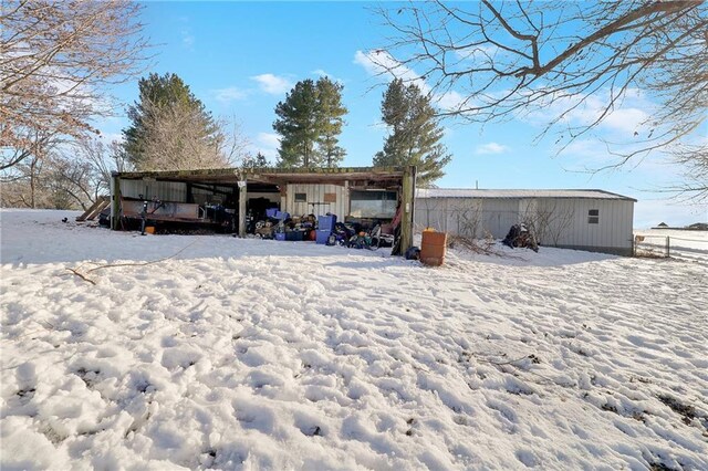 snow covered property featuring an outbuilding