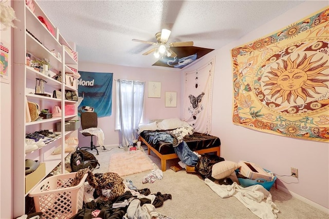 carpeted bedroom with a textured ceiling, a ceiling fan, and baseboards