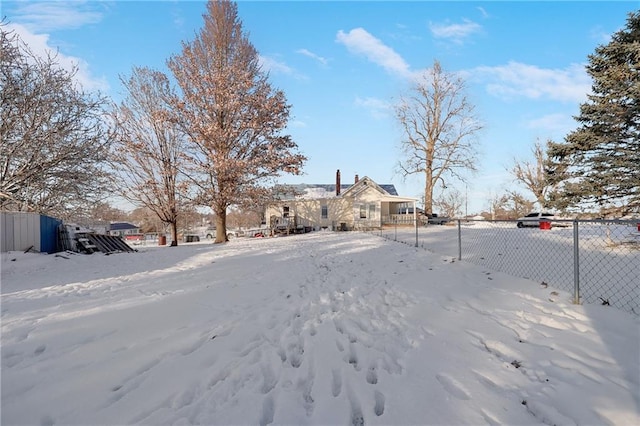 yard covered in snow featuring fence