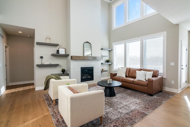 living area with a wealth of natural light, a fireplace, and wood finished floors