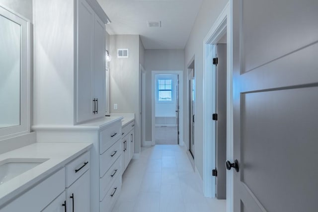 bathroom with two vanities, tile patterned flooring, visible vents, and a sink