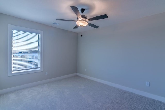 unfurnished room with visible vents, carpet, a ceiling fan, and baseboards