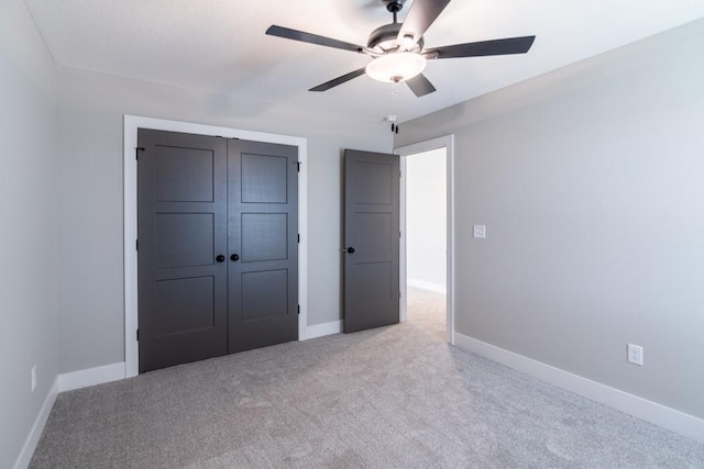 unfurnished bedroom with ceiling fan, baseboards, a closet, and light colored carpet