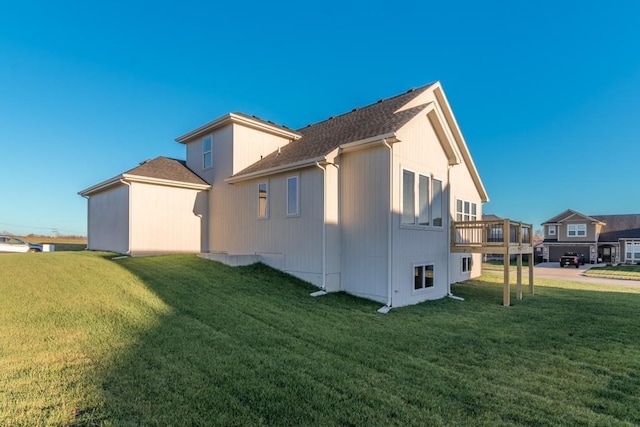 view of side of property featuring a residential view, a lawn, and a wooden deck