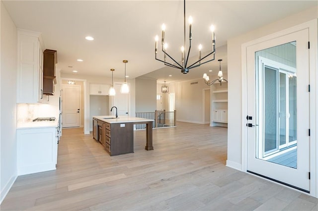 kitchen with light countertops, light wood-type flooring, a sink, and white cabinets