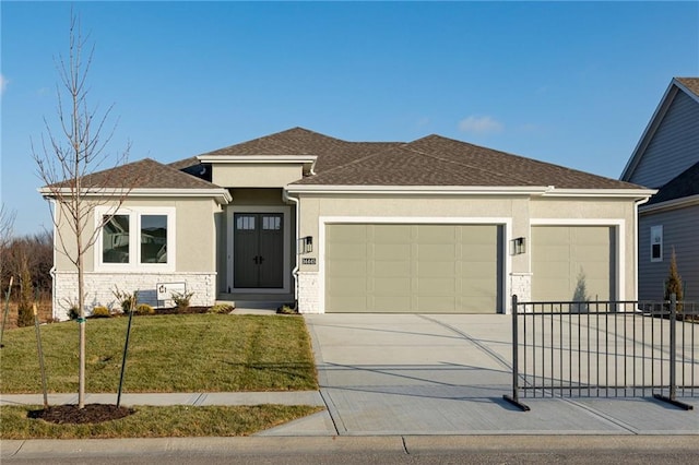 prairie-style house featuring a shingled roof, concrete driveway, an attached garage, a front yard, and stucco siding